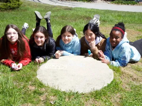 a group of girls sitting on a rock