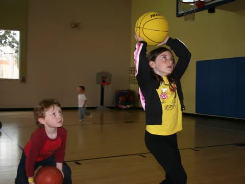 a person holding a ball and a boy holding a basketball