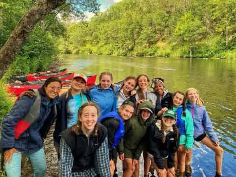 a group of people posing for a photo in front of a river