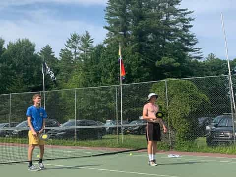 a couple of people play tennis