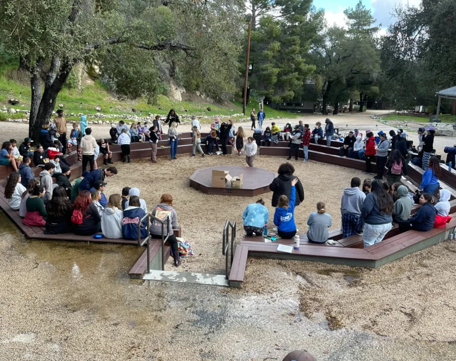 a group of people sitting on a bench in front of a river