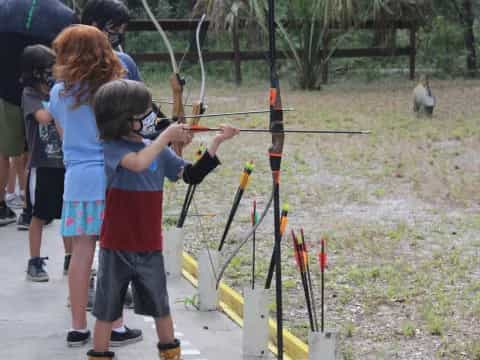 a group of kids shooting bows