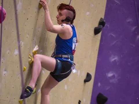 a woman climbing a rock wall