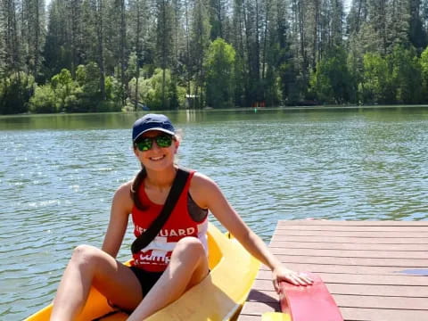 a woman in a life jacket on a boat in a lake