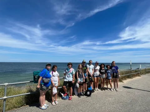 a group of people posing for a photo on a path by the water