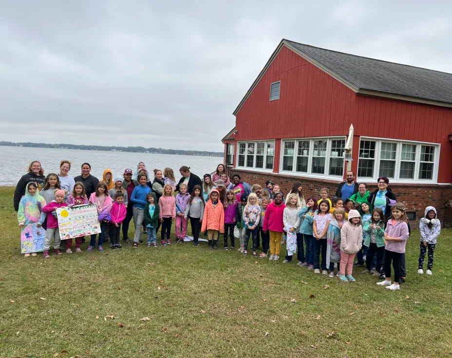 a group of children posing for a photo in front of a house