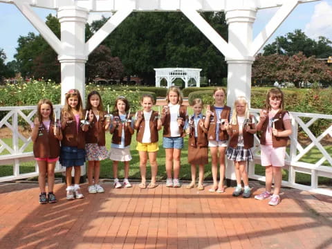 a group of children posing for a photo in front of a white building