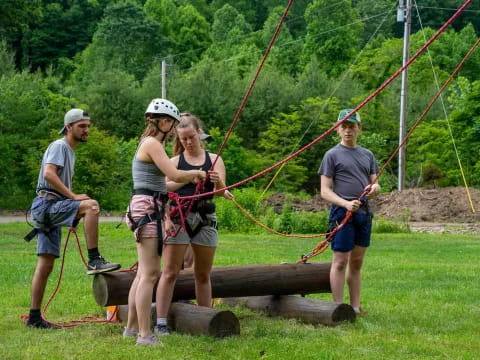 a group of people on a wooden platform with ropes and a rope