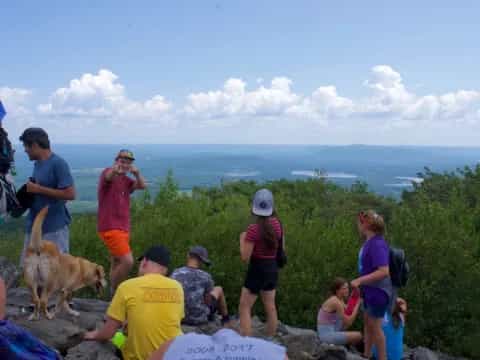 a group of people and a dog on a mountain