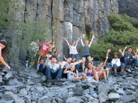 a group of people posing for a photo on a rocky area