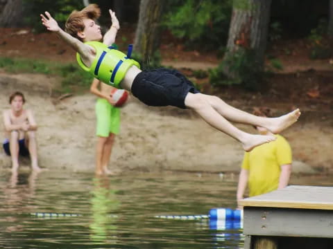 a boy jumping into a pool