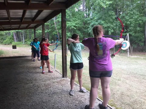 a group of people playing with bows and arrows