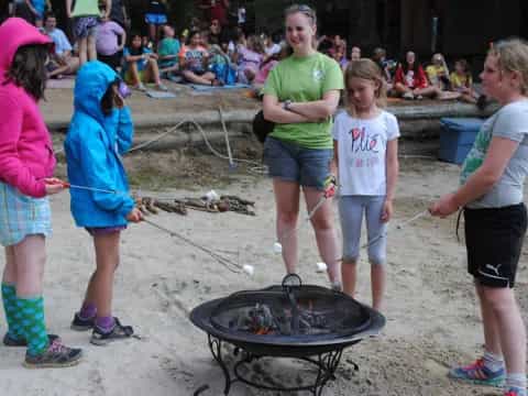 a group of children playing with a fire pit