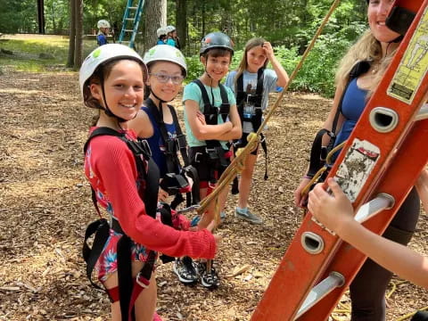 a group of kids wearing helmets and holding a large orange object