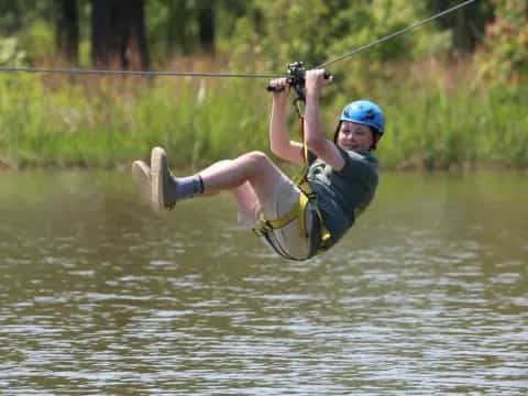 a man in a harness holding a rope above water