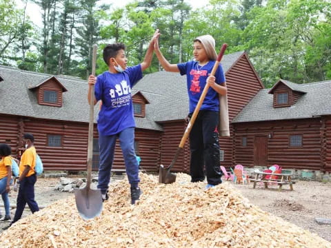 a couple of boys shoveling dirt