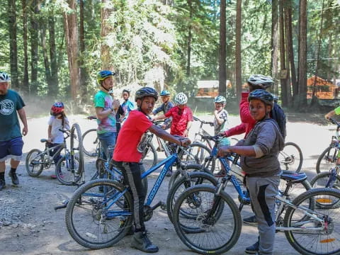 a group of people with bicycles in a forest