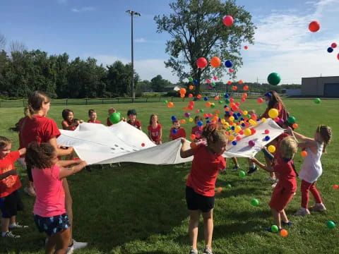 a group of children playing with a large white tent