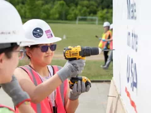 a person wearing a helmet and holding a drill