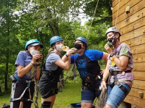 a group of people wearing helmets and harnesses