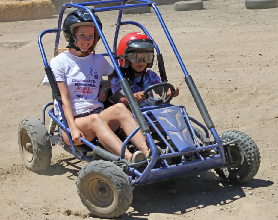 a couple of kids on a toy vehicle