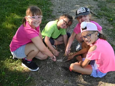 a group of children playing with a snake in the grass