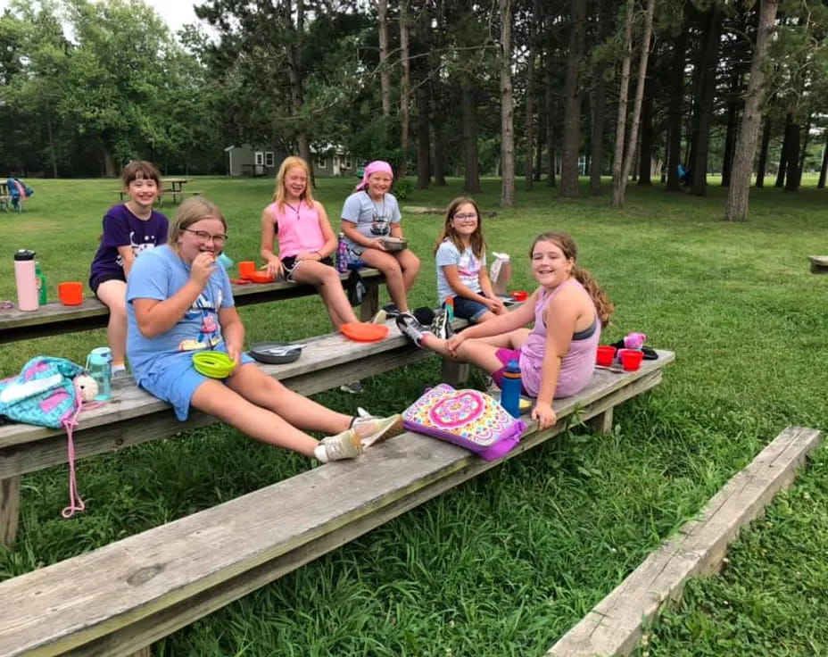 a group of people sitting on a picnic table