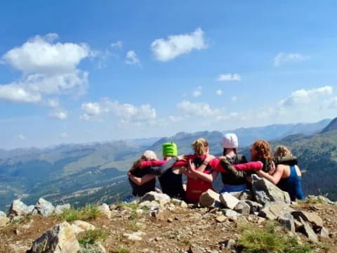 a group of people sitting on a rocky hill