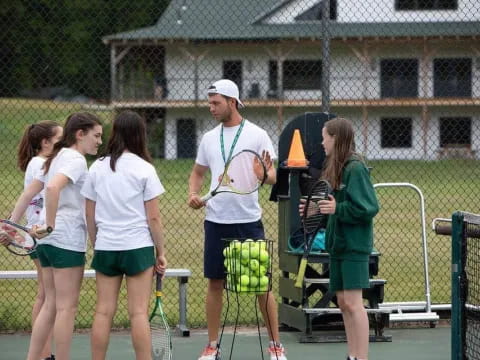 a group of people stand around a tennis court