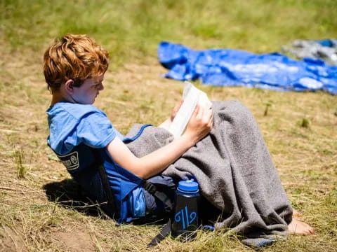 a person lying on the ground reading a book