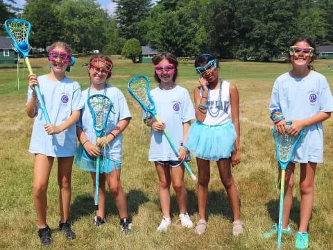 a group of girls wearing blue uniforms and holding bows and arrows