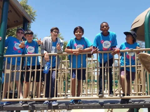 a group of people standing on a metal fence