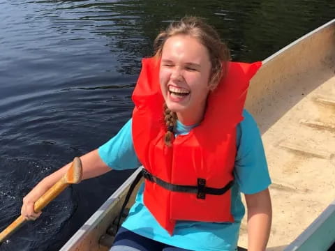 a girl in a life jacket on a boat