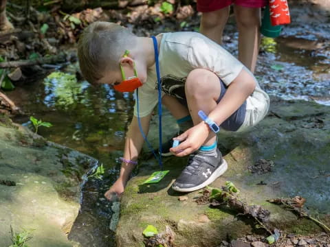 a boy squatting on a rock