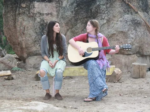 a couple of women playing guitar