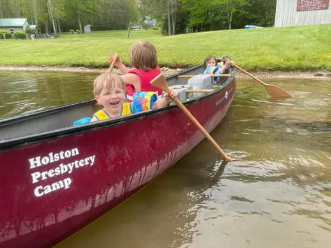 a group of kids in a canoe