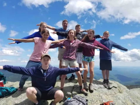 a group of people posing for a photo on a mountain