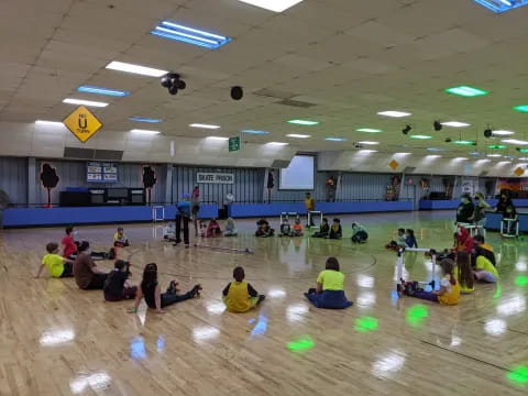 a group of people sitting on the floor in a gym