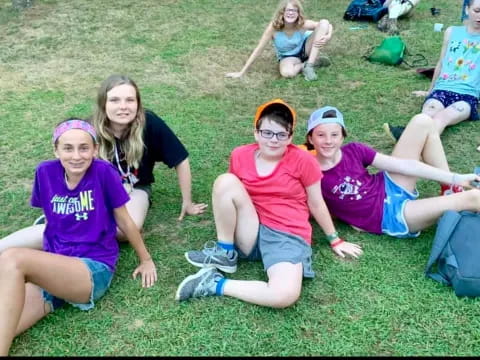 a group of people sitting on the grass