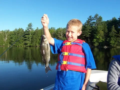 a boy holding a fish