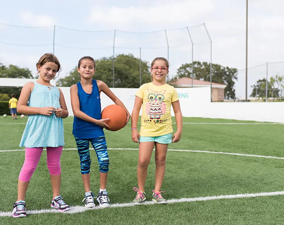 a group of girls holding a basketball