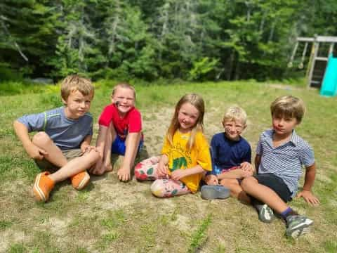 a group of kids sitting on the grass