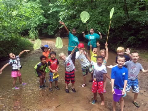 a group of kids holding up green objects