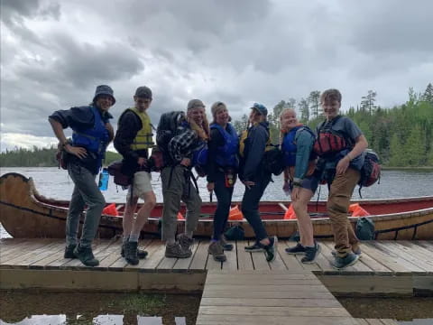 a group of people posing for a photo on a dock