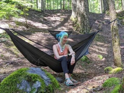 a person sitting on a log in the woods