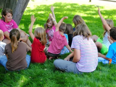 a group of children sitting on the grass