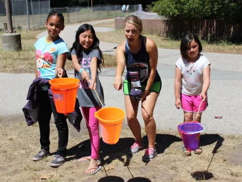 a group of children holding buckets