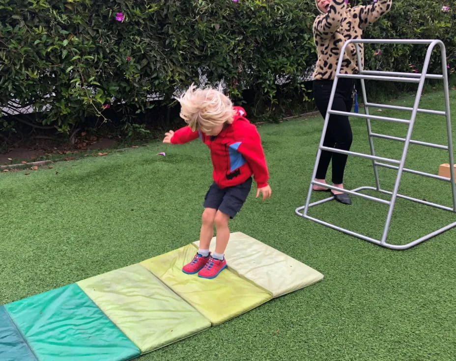 a child standing on a trampoline