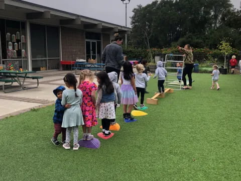 a group of children standing on grass