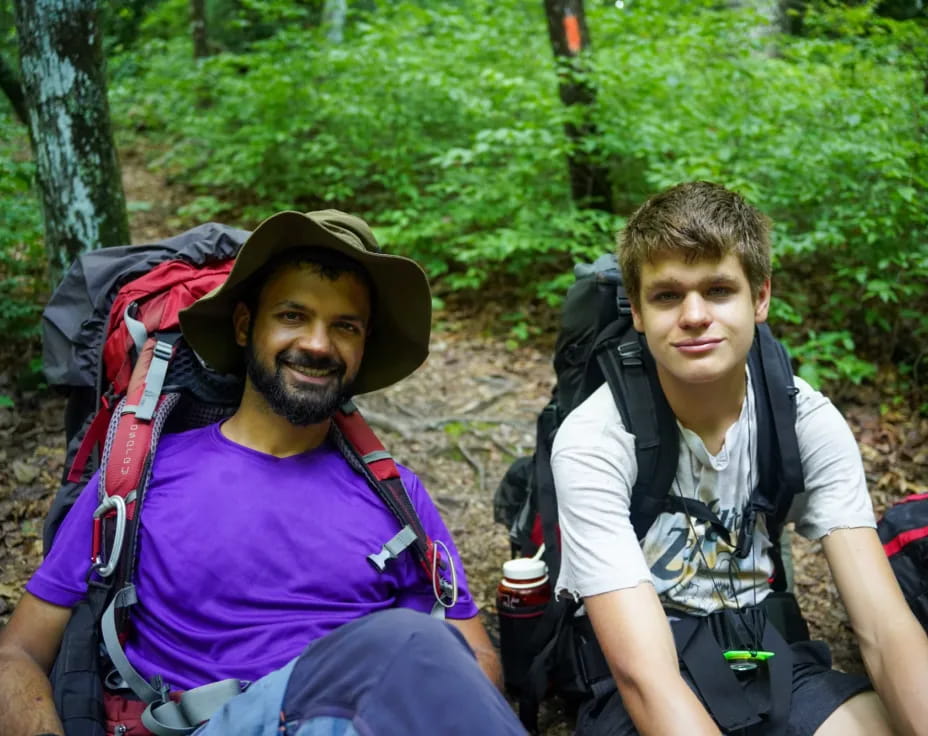 two men sitting on a rock